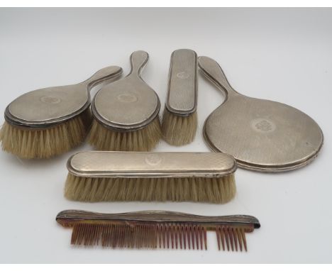 A five piece silver dressing table set, comprising two clothes brushes, two hair brushes a mirror and a comb, all with lattic