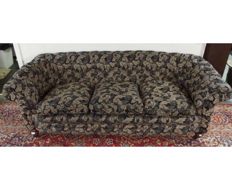 A Victorian button back three seater settee upholstered in a black and gilt acanthus leaves fabric on turned mahogany support