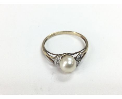 A 9ct gold eimg set with a central cultured pearl and six small diamonds. Approx 1.8g and approx size S. Shipping category A.