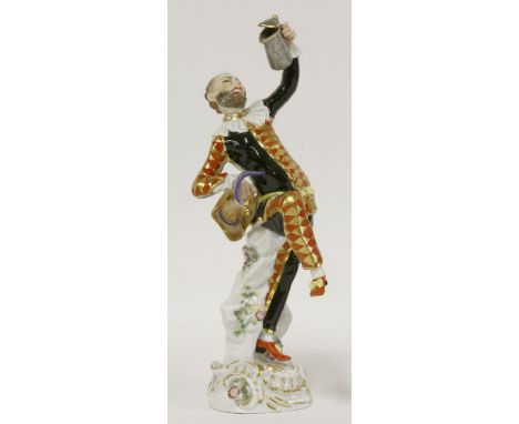 A Meissen drunken Harlequin,after JJ Kändler, the bearded figure in a contrapposto stance in gilt-lozenged red and black cost