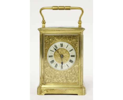 A brass carriage clock, with an engraved face, with Roman numerals on an ivorine chapter ring, with a swing handle,15cm high