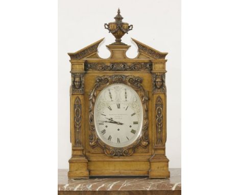 A Victorian oak musical bracket clock, the case carved with classical decoration, including masks, scrolls swags and shell, a