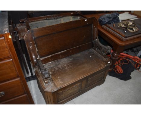 An early to mid 20th Century oak monks bench having lion arms, needs a freshen up