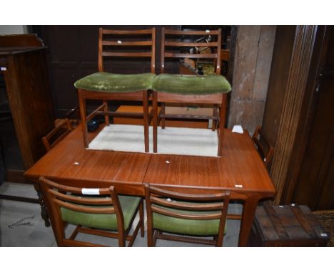 A vintage G plan or similar teak extending dining table with integral butterfly style centre leaf, and set of six similar lad