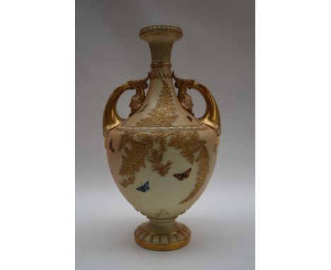 A Royal Worcester twin handled vase with a flared rim, decorated with butterflies and raised gilt ferns on a spreading foot, 