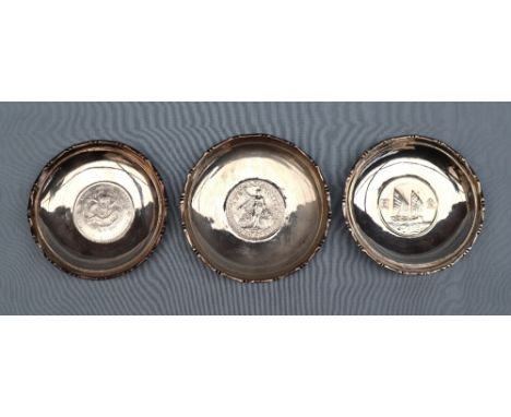 Chinese silver - A set of three Waikee sterling silver pin trays each set with a coin to the base, marked Made in Hong Kong, 