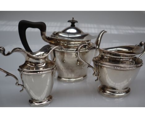 A George V silver three piece tea set, of oval form with swags on a pedestal foot, Birmingham, 1917, Williams (Birmingham) Lt