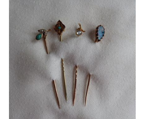 A black opal stick pin to a 9ct yellow gold setting and pin together with a 9ct gold turquoise set pin and two other stick pi