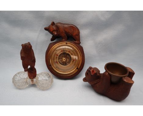 A Black Forest bear barometer together with a carved bear and cut glass table salt and another of a bear on its back holding 