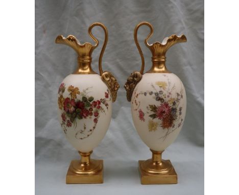 A pair of Royal Worcester porcelain ewers with wavy spout, mask terminal handles, the ovoid body decorated with flowers and l