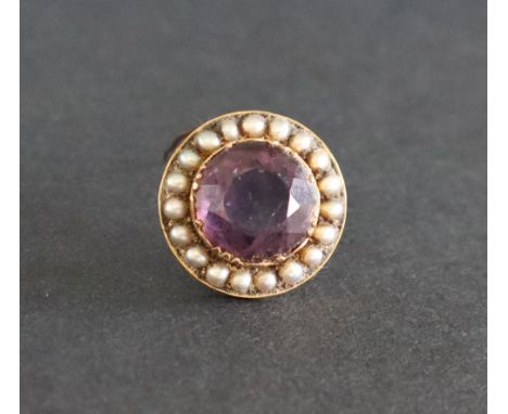 An amethyst and seed pearl brooch of circular form to a yellow metal setting, 25mm diameter, approximately 7.5 grams