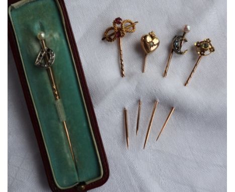 A 15ct yellow gold peridot and seed pearl stick pin together with a 9ct gold heart shaped seed pearl stick pin, a ruby and ye