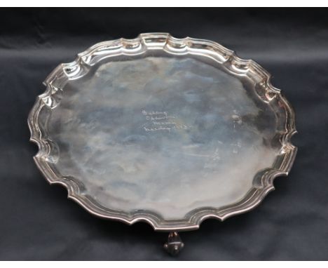 An Elizabeth II silver salver with a shaped edge on three scrolling feet, Birmingham, 1953, R N Hollings & Co, 30.5cm diamete