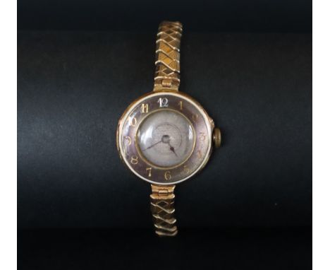 An 18ct gold lady's wristwatch the outer rim with Arabic numerals with a silvered dial, 28mm diameter, on an expanding bracel