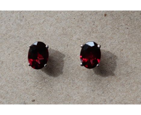 A pair of rhodolite garnet earrings to a silver setting and post