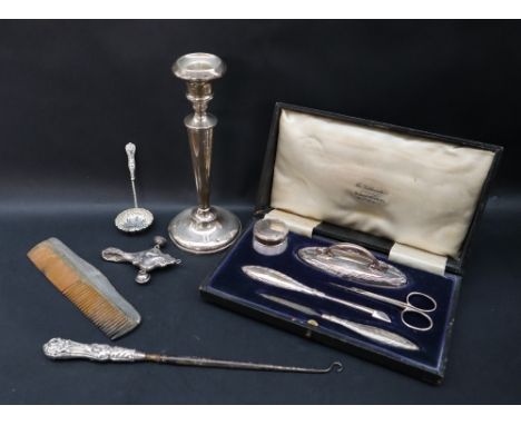 A George V silver manicure set, including a nail buffer, scissors, nail file etc, cased together with a silver candlestick, s