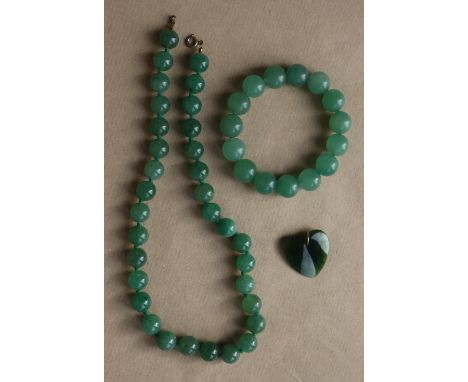 A green jade beaded necklace, 46cm long together with a similar beaded bracelet and a heart pendant