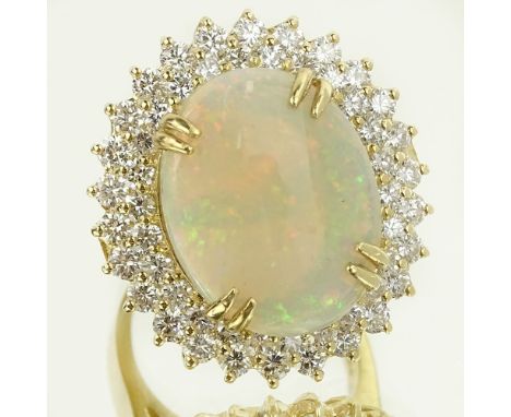 Lady's Large 9.0 Carat White Opal, 3.15 Carat Round Cut Diamond and 14 Karat Yellow Gold Ring. Opal measures 14 x 18mm. Diamo