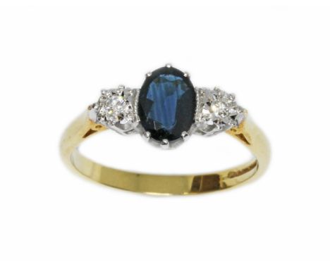 A diamond and sapphire ring, the central oval dark blue sapphire measuring approximately 7mm x 5mm, hallmarked 18ct gold band