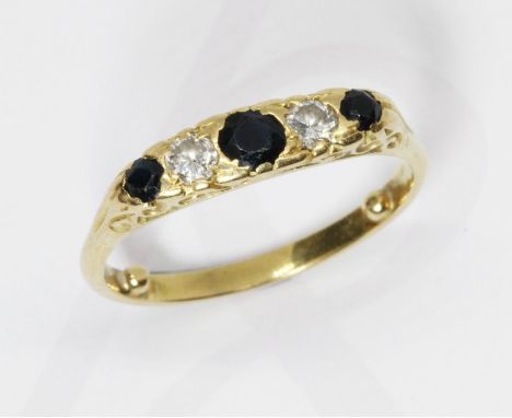 A five stone diamond and sapphire ring, scroll setting, yellow metal band unmarked, gross weight 4.6g, size R.  