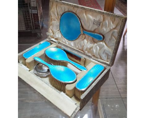 An early 20th century cased hallmarked silver and enamel dressing table set.  