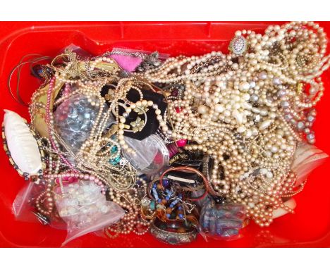 A large red plastic box of assorted mainly vintage costume jewellery.  