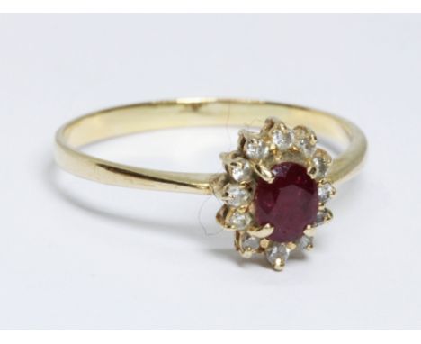 A ruby and diamond cluster ring, the oval cluster measuring approximately 9.5mm x 7.8mm, band marked '18kt', gross weight 2.4