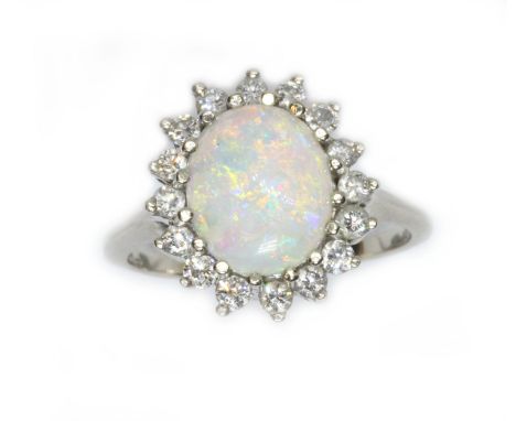 An opal and diamond cluster ring, the oval opal cabochon measuring approximately 12.58mm x 9.93mm, depth 3.41mm, surrounded b