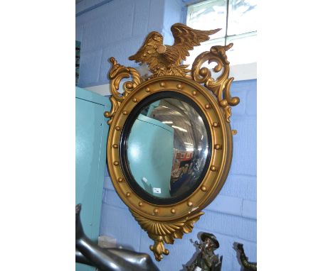 A reproduction Georgian style gilt wood porthole mirror with eagle mount, approx 100cm high (a/f)