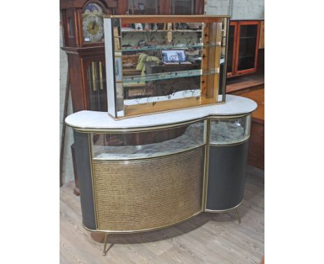 A 1960s retro bar of shaped form with brass and black moulding, marble effect top, above curved glass and lower padding and s