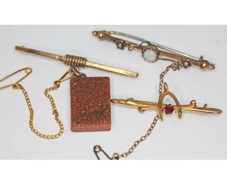 A group of three bar brooches comprising one hallmarked 9ct gold and set with a sunstone miniature book, another hallmarked 9