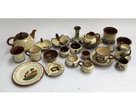 A collection of Torquay motto ware pottery, consisting of pin dishes, candlesticks, teapot, cups etc 