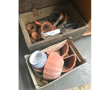 A pine chest together with a wooden crate, each containing a quantity of terracotta and other ceramic planters 