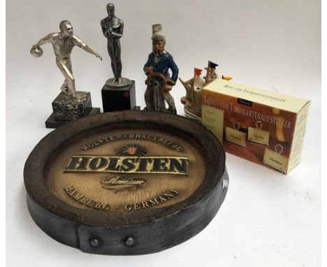 A Holsten, Germany beer advertising plaque in the form a barrel end; together with several trophies and ceramic figures 