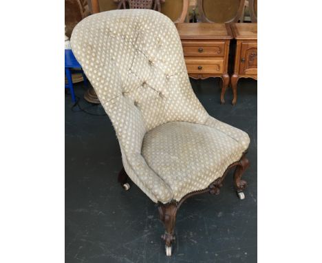 A buttonback continental bedroom chair, serpentine front with carved apron and scrolling cabriole legs, on ceramic casters 