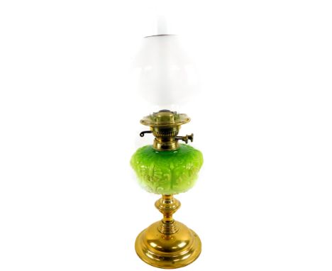 A 20thC oil lamp, with clear glass funnel, milk and gilt highlighted glass shade and moulded green glass reservoir, on an inv