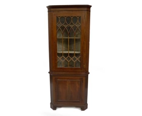 A George III mahogany standing corner cupboard, with dentil moulded cornice, astragal glazed single door with flamed banding 