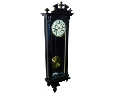 A 20thC Vienna wall clock, the 17cm Dia. enamel dial in later ebonised three part glass case, with heavily carved finials, re