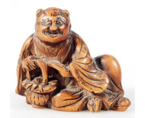 A Japanese Taisho period carved netsuke, formed as a gentleman in recumbent pose in flowing robes, soft wood, lacquered and c