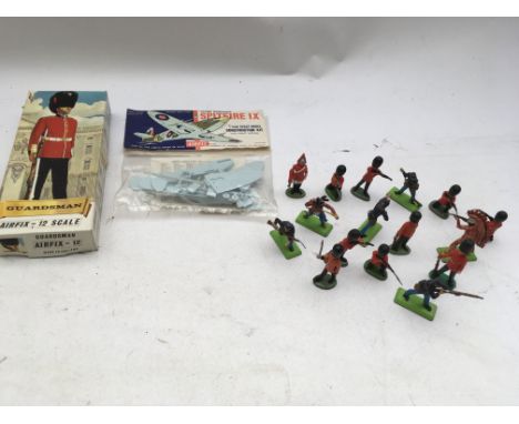 A small collection of Britains soldiers, an Airfix 1:72 scale bagged Spitfire Ix construction kit and an Airfix 1:12 scale Gu