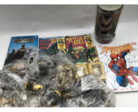 A box containing a Batman and Spider-Man books, also a Rolling Stones Bobble head figure and 2 Planet of the apes comics with