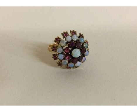 An opal and ruby cluster ring in 14 carat mount. Approx. 5 grams. Est. £180 - £220.