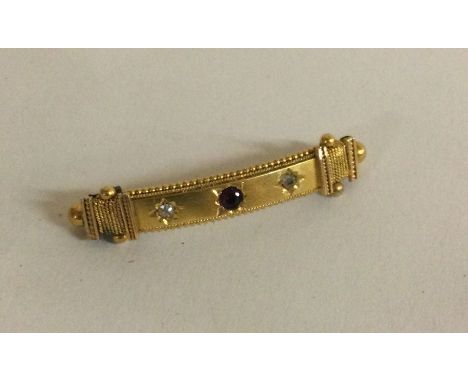 A 15 carat gold ruby and diamond three stone brooch. Approx. 4 grams. Est. £80 - £120.