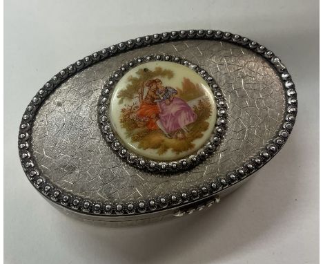 A silver and porcelain box with lift-off lid depicting a scene with a man and a woman. Approx. 189 grams. Est. £30 - £50.
