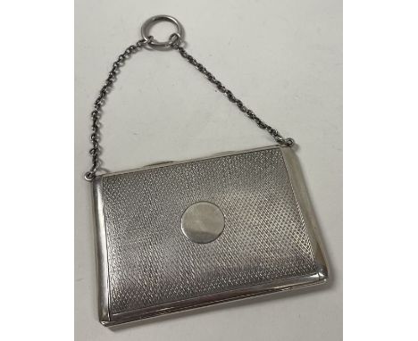 SAMPSON MORDAN: An engine turned silver travelling card case. London 1919. Approx. 81 grams. Est. £180 - £220.