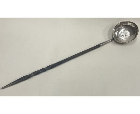 A large 19th Century silver ladle with coin inset and whalebone handle. Approx. 54 grams. Est. £60 - £80.