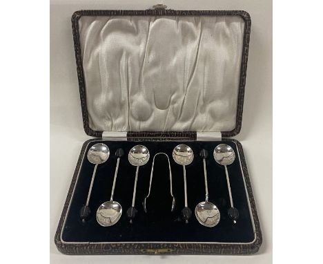 A set of six cased silver coffee bean spoons and tongs. Birmingham 1933. By SLD. Approx. 49 grams. Est. £40 - £60.