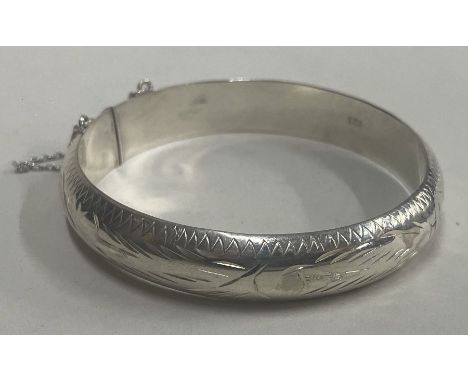 An engraved silver bangle. Approx. 18 grams. Est. £20- £30.