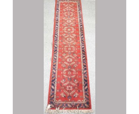 A woollen runner, on a red ground, 70 x 300cm 