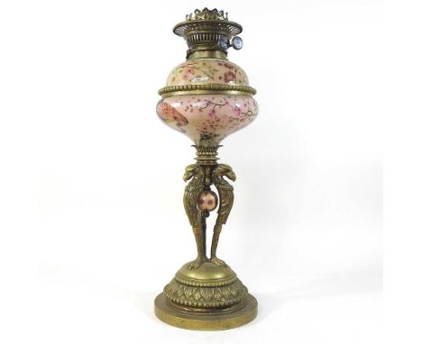 An ornate 19th century brass and pottery oil lamp, the base having eagle supports, on a domed base, 50cm highCondition report